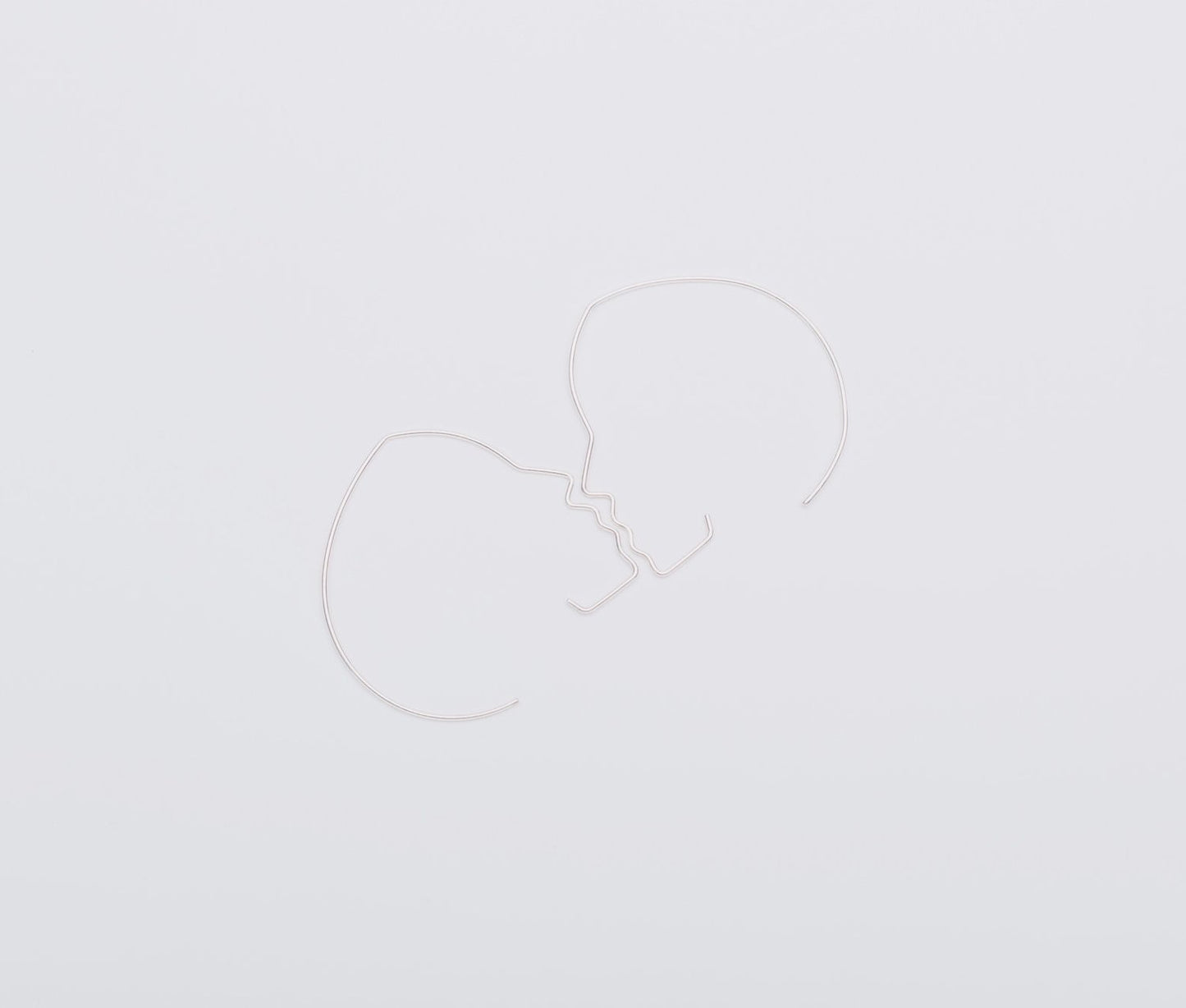 Two white heart-shaped balloons on a light gray background