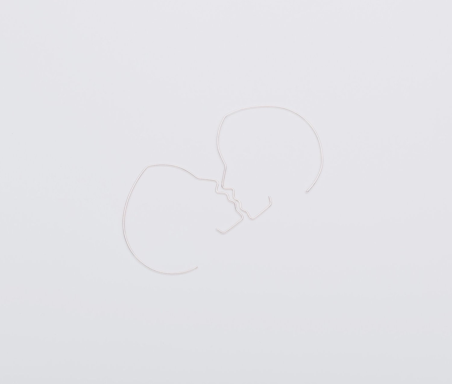 Two white heart-shaped balloons on a light gray background