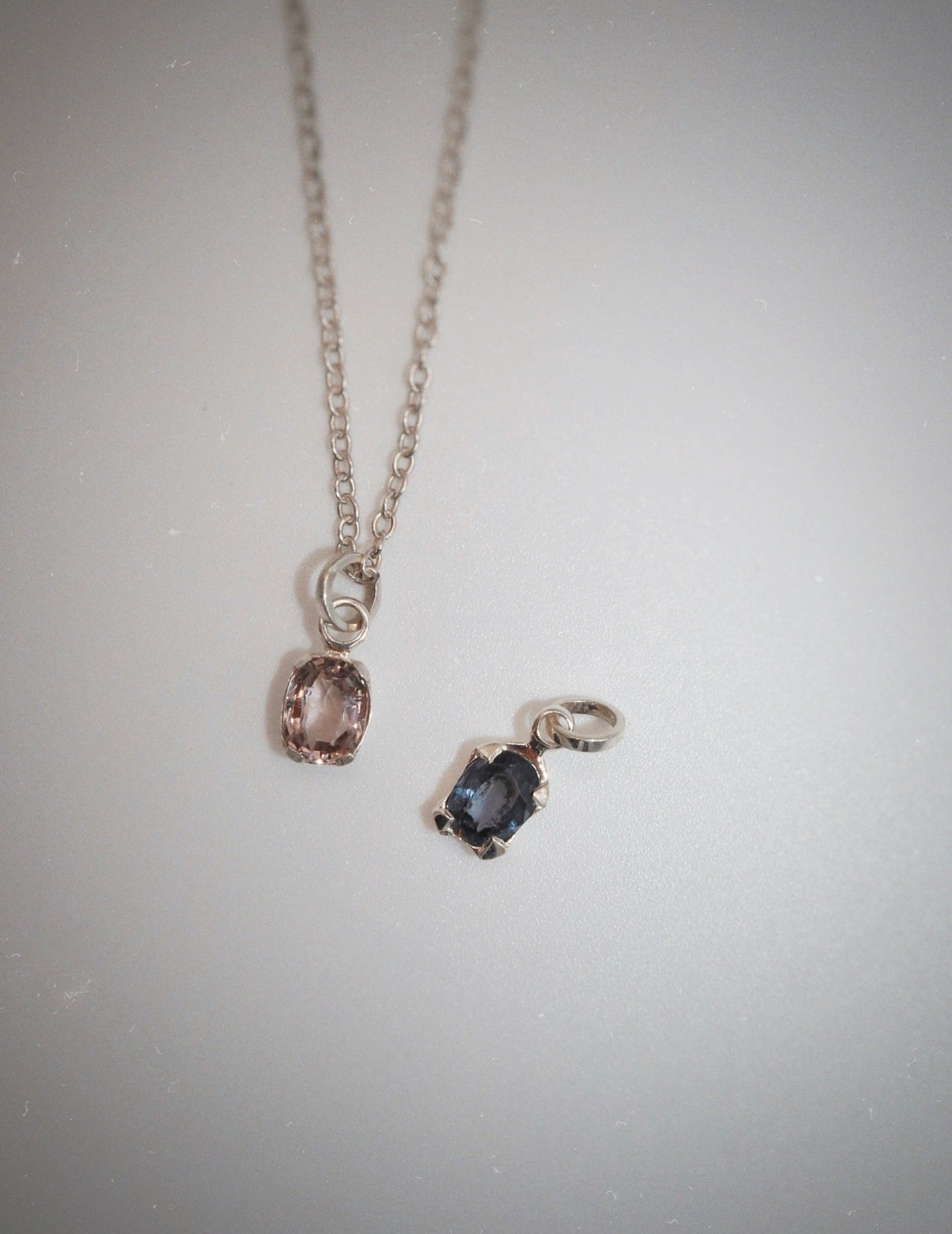 Necklace with two pendant charms on a light gray background