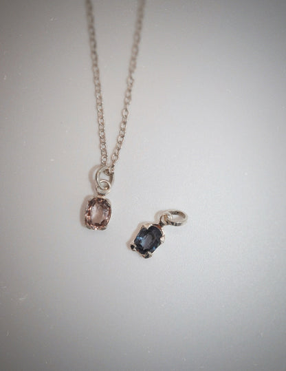 Necklace with two pendant charms on a light gray background