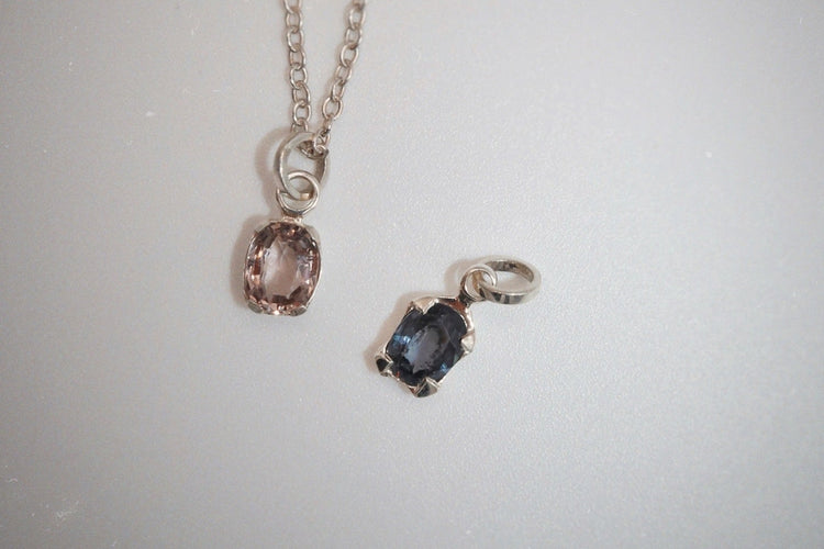 Necklace with two pendant charms on a light gray background