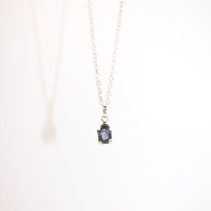 Necklace with a pendant featuring a blue gemstone on a white background