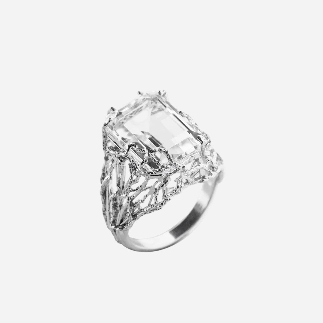 Silver ring with a large diamond on a white background