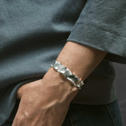Silver bracelet on a wrist with a blurred background