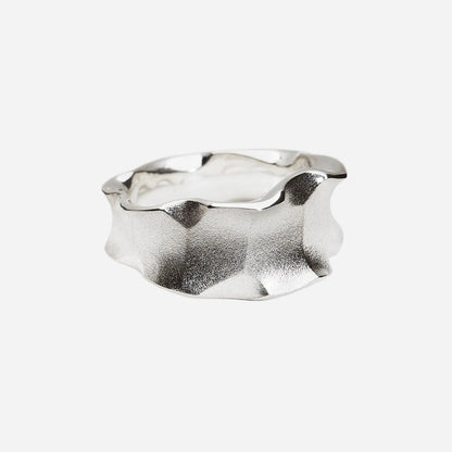 Silver ring with a wavy design on a white background
