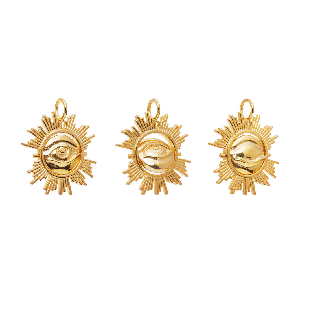 Three gold sun-shaped earrings with eye designs on a white background