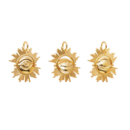 Three gold sun-shaped earrings with eye designs on a white background