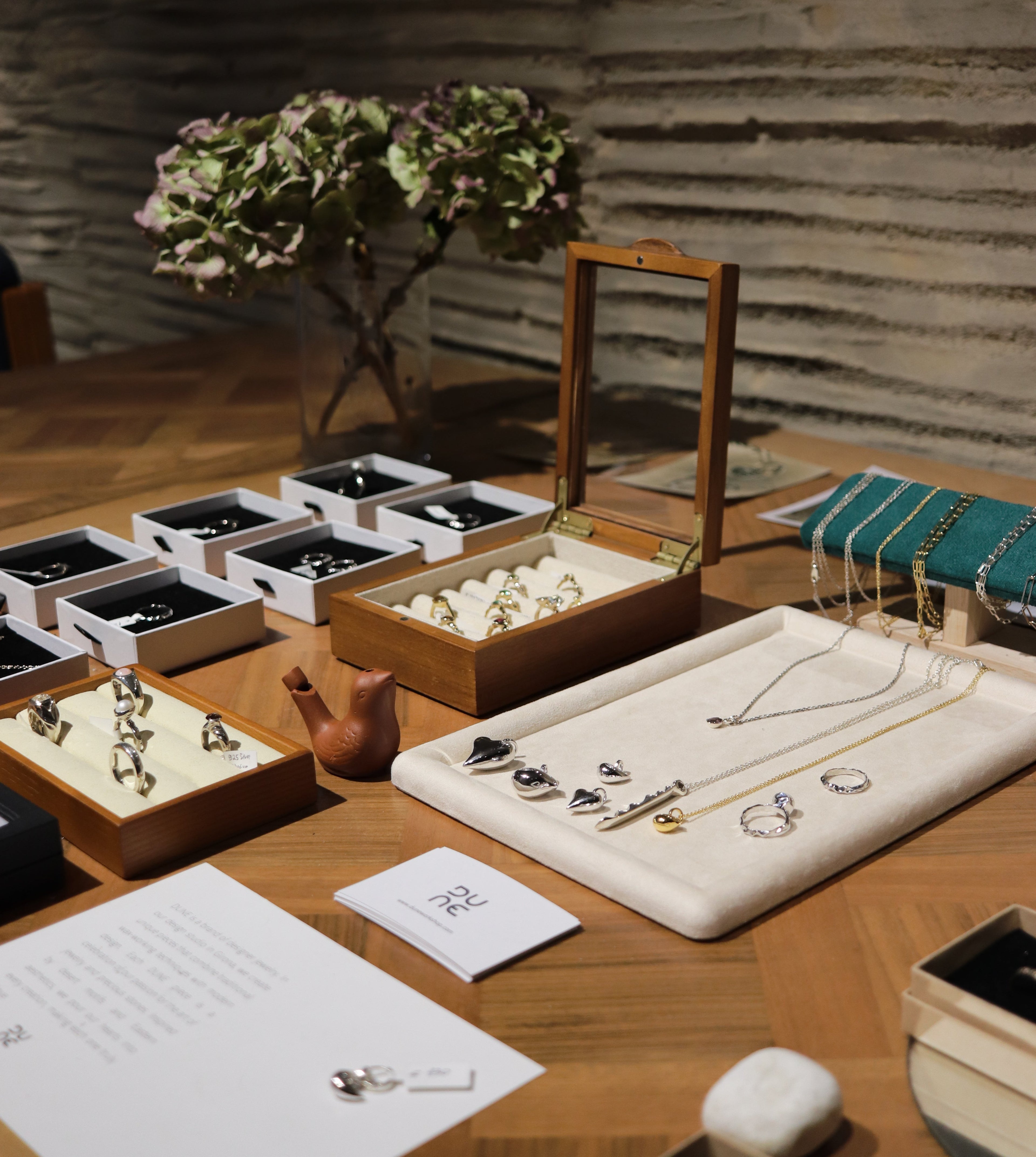 Wooden jewelry display with various earrings on a wooden table.