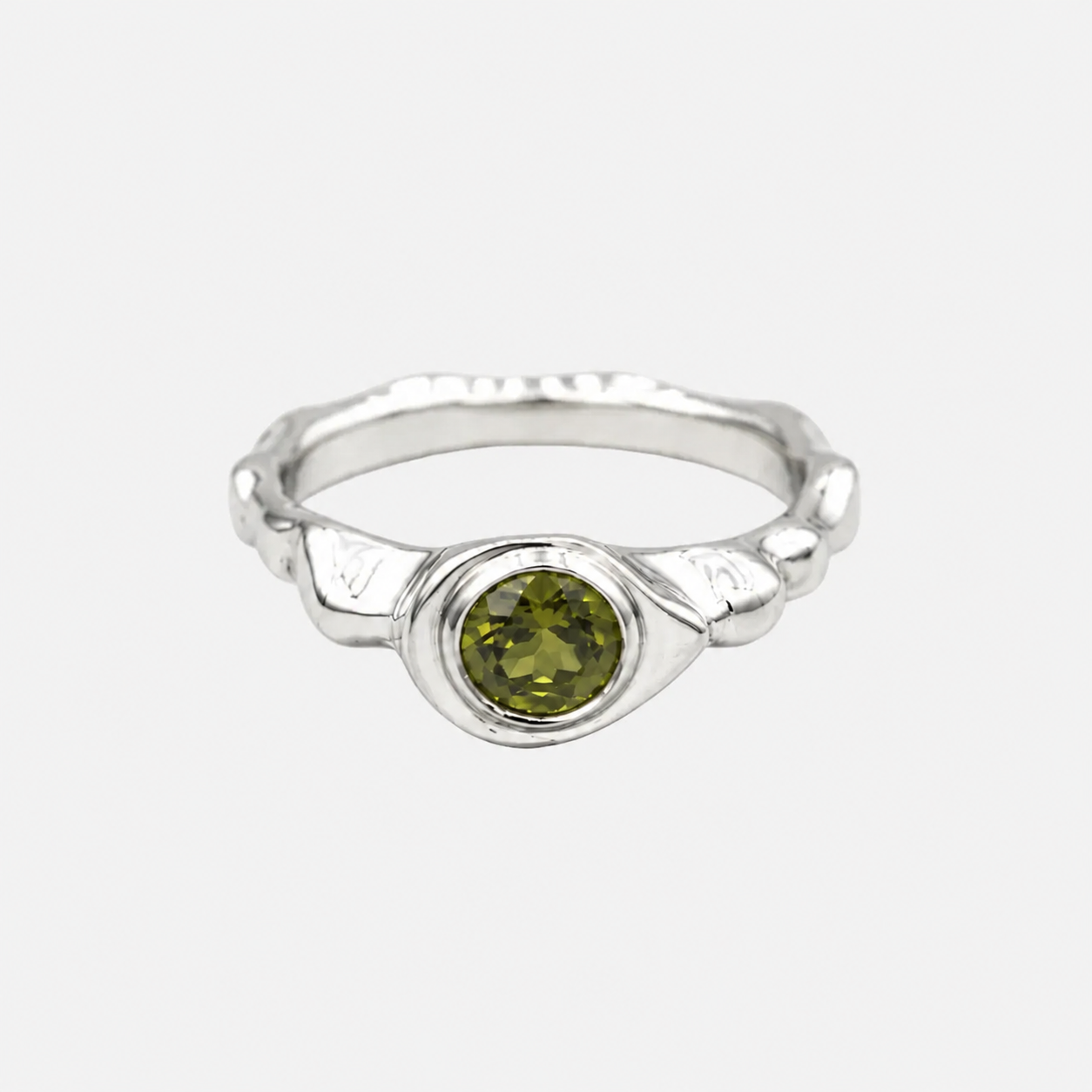 Silver ring with a green gemstone on a white background