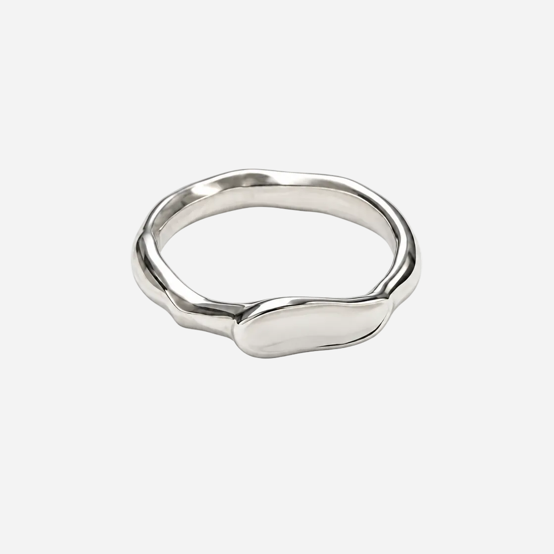 A polished silver ring with an organic, wavy, fluid silhouette, photographed on a seamless white background.