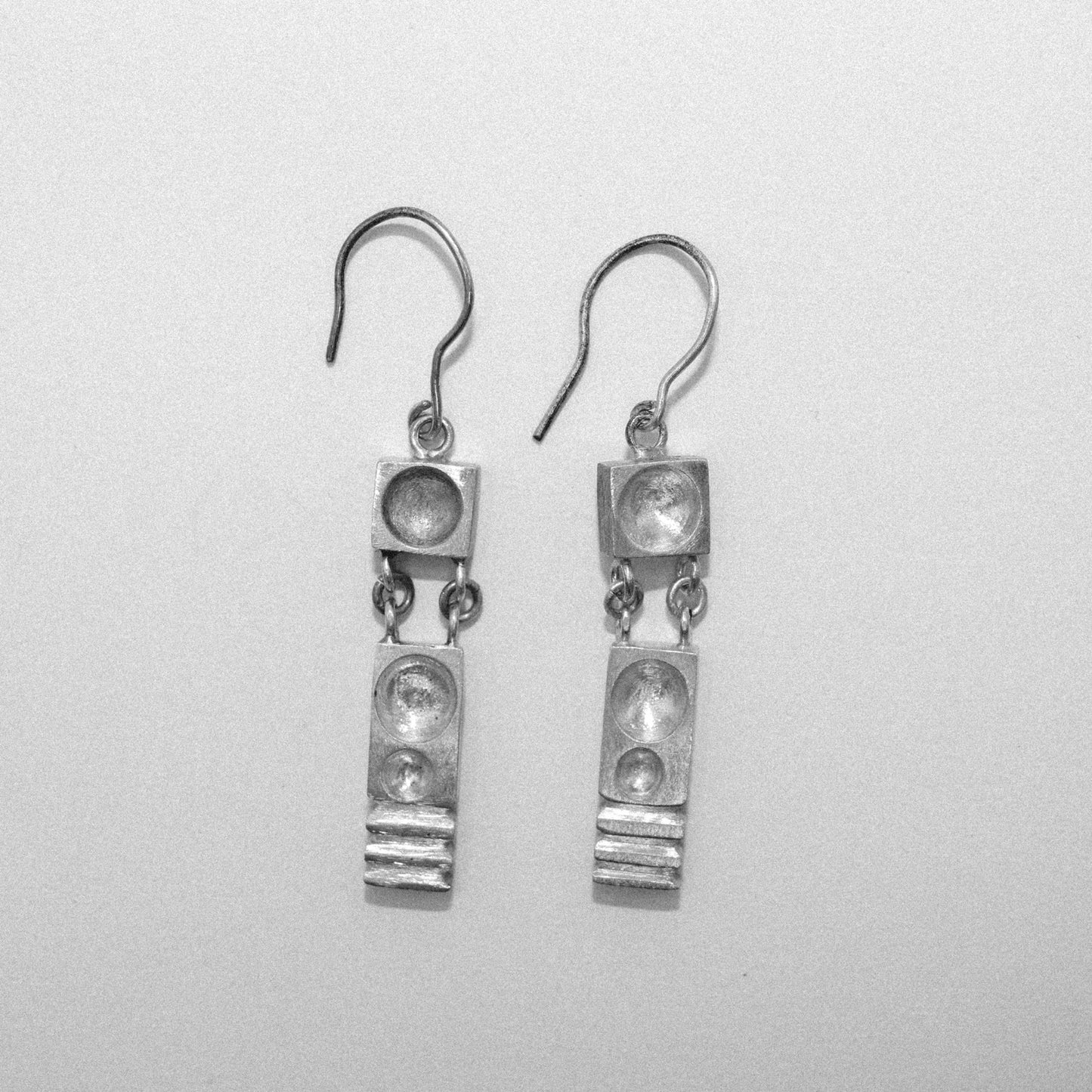 Pair of silver earrings on a light gray background