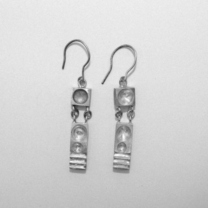 Pair of silver earrings on a light gray background