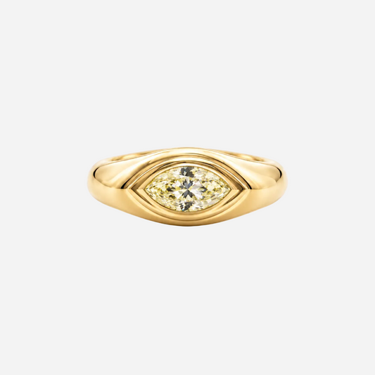 A yellow gold eye-shaped ring featuring a marquise-cut yellow diamond in the center, set against a plain light gray background.