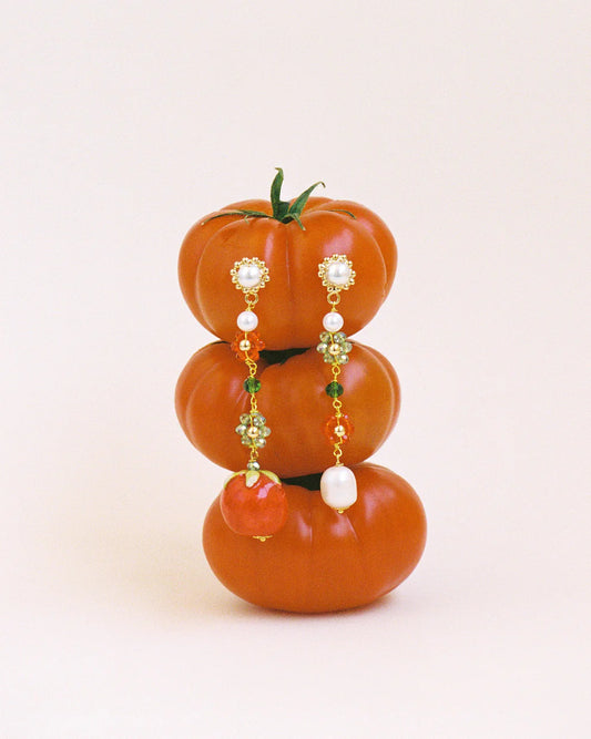 Decorative earrings shaped like pumpkins on a white background
