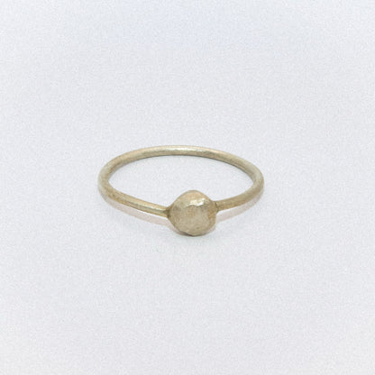 Gold ring with a round bead on a white background