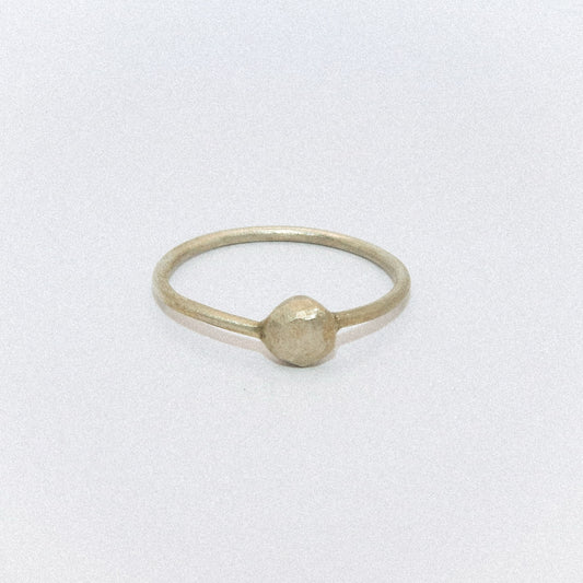 Gold ring with a round bead on a white background