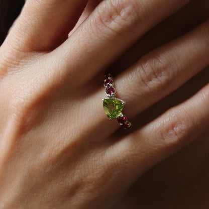 Close-up of a hand wearing a ring with a green gemstone.