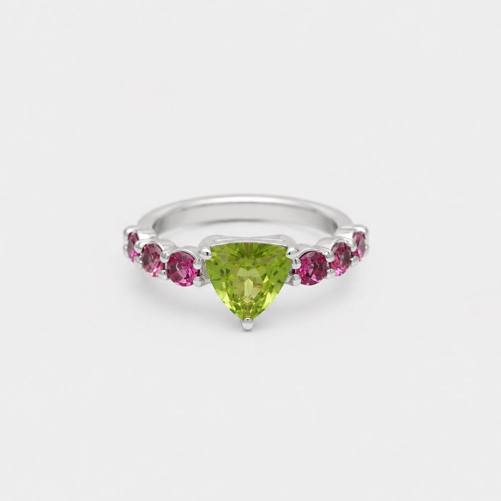 Silver ring with a green gemstone and pink stones on a white background