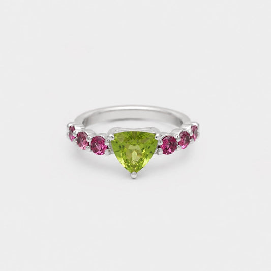 Silver ring with a green gemstone and pink stones on a white background