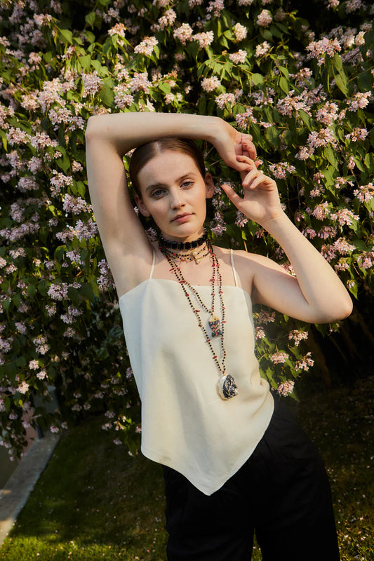 Woman posing with arms raised against a floral background