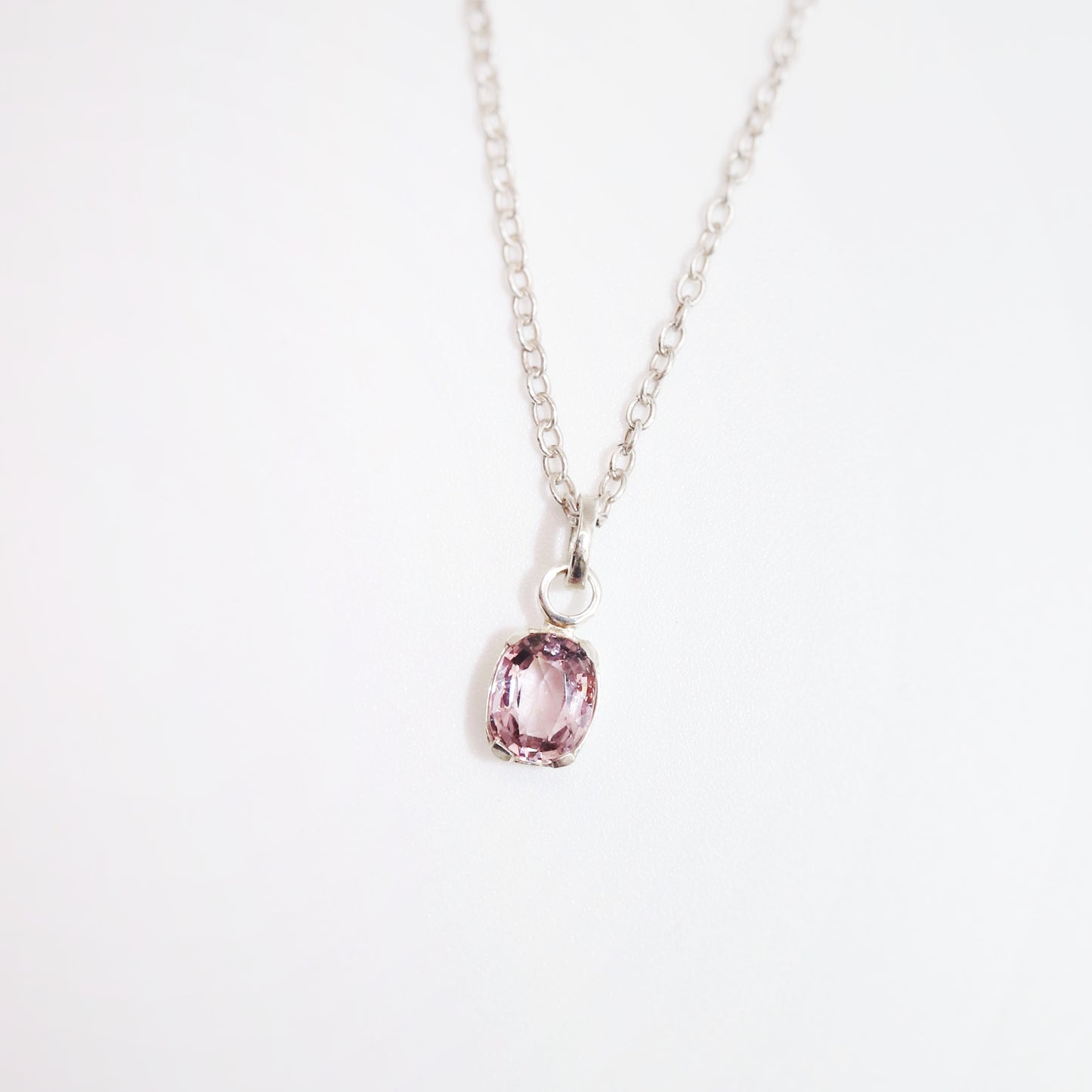 Necklace with a pink gemstone pendant on a white background