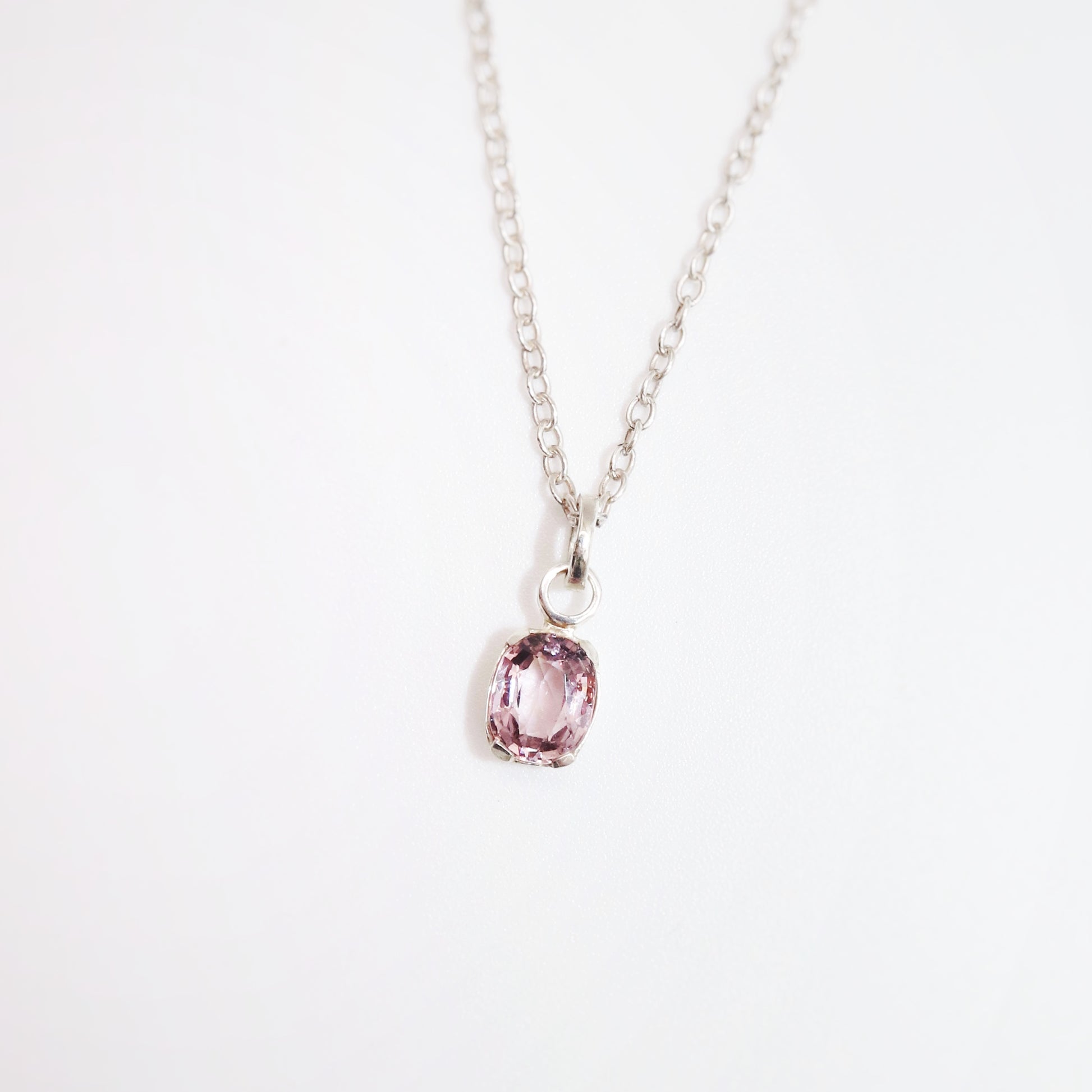 Necklace with a pink gemstone pendant on a white background