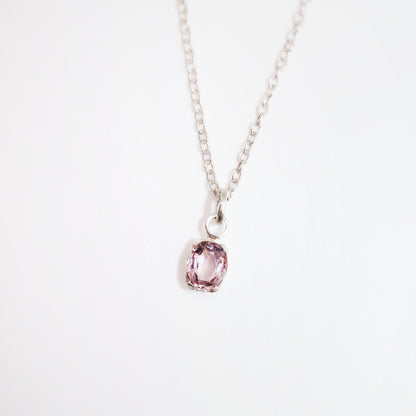 Necklace with a pink gemstone pendant on a white background