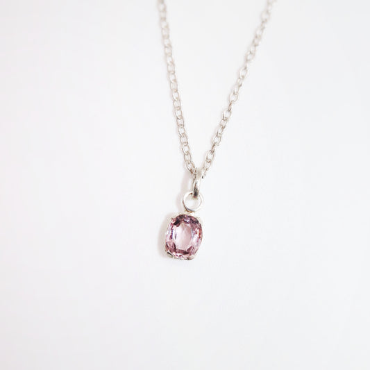 Necklace with a pink gemstone pendant on a white background