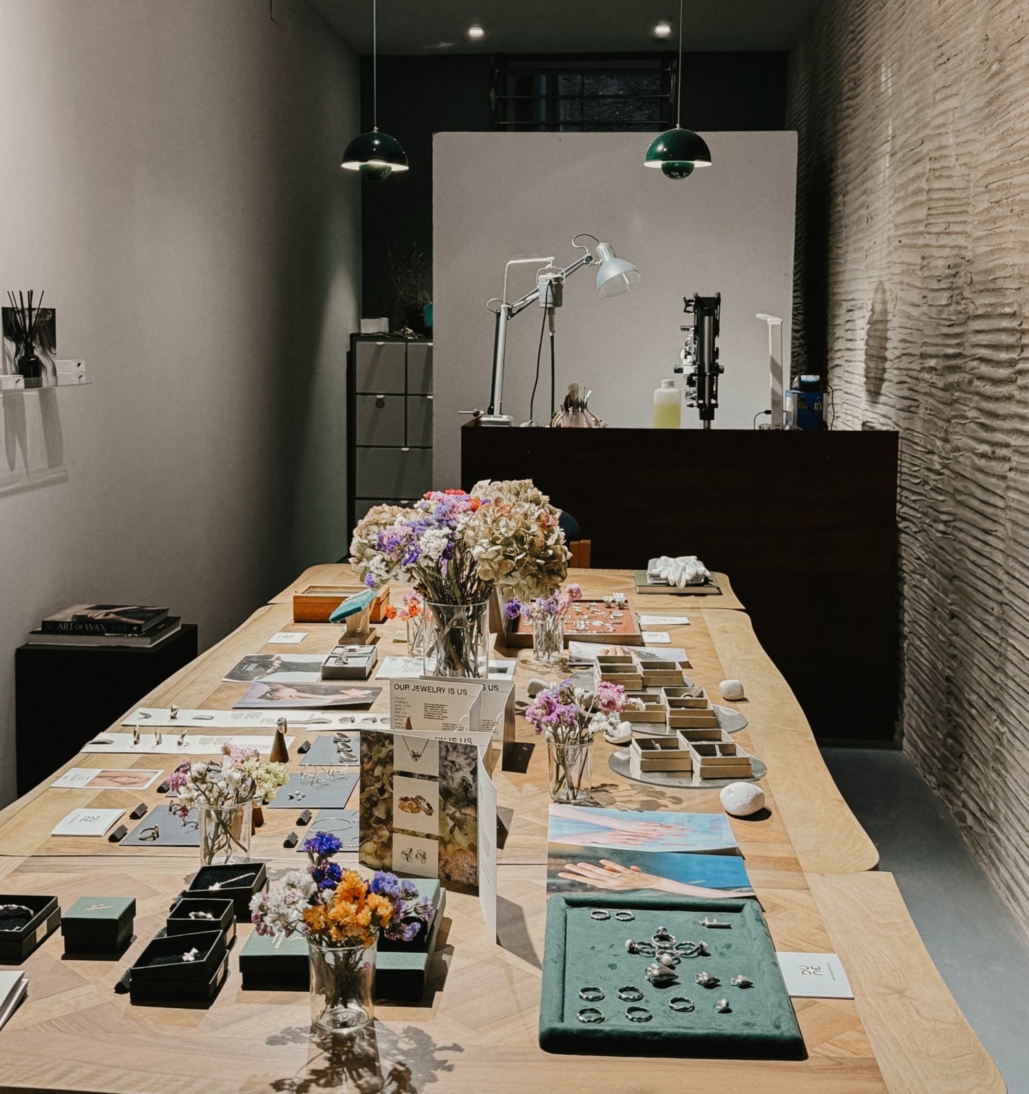 Long wooden table with decorative items in a modern room with exposed brick wall.