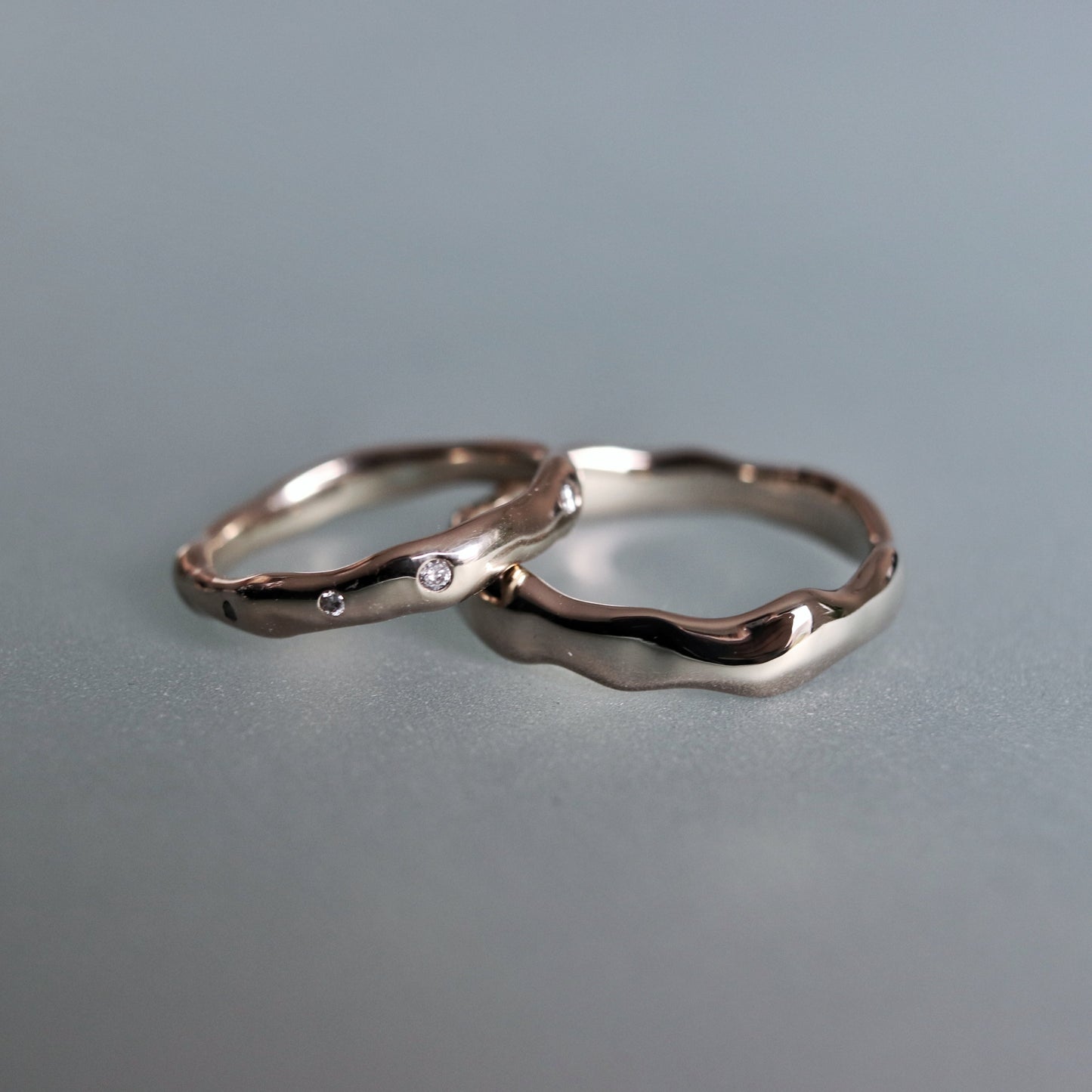 Two silver rings on a gray surface