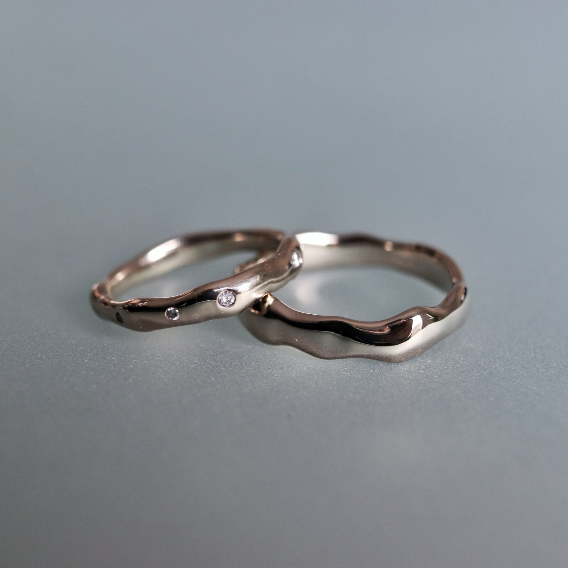 Two silver rings on a gray surface