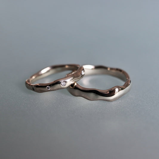 Two silver rings on a gray surface