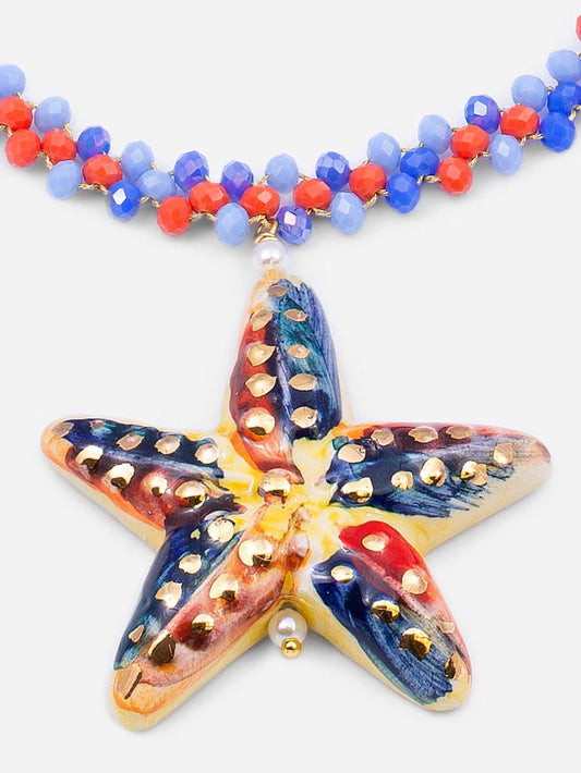 Starfish-shaped pendant on a beaded necklace with red, blue, and gold colors.