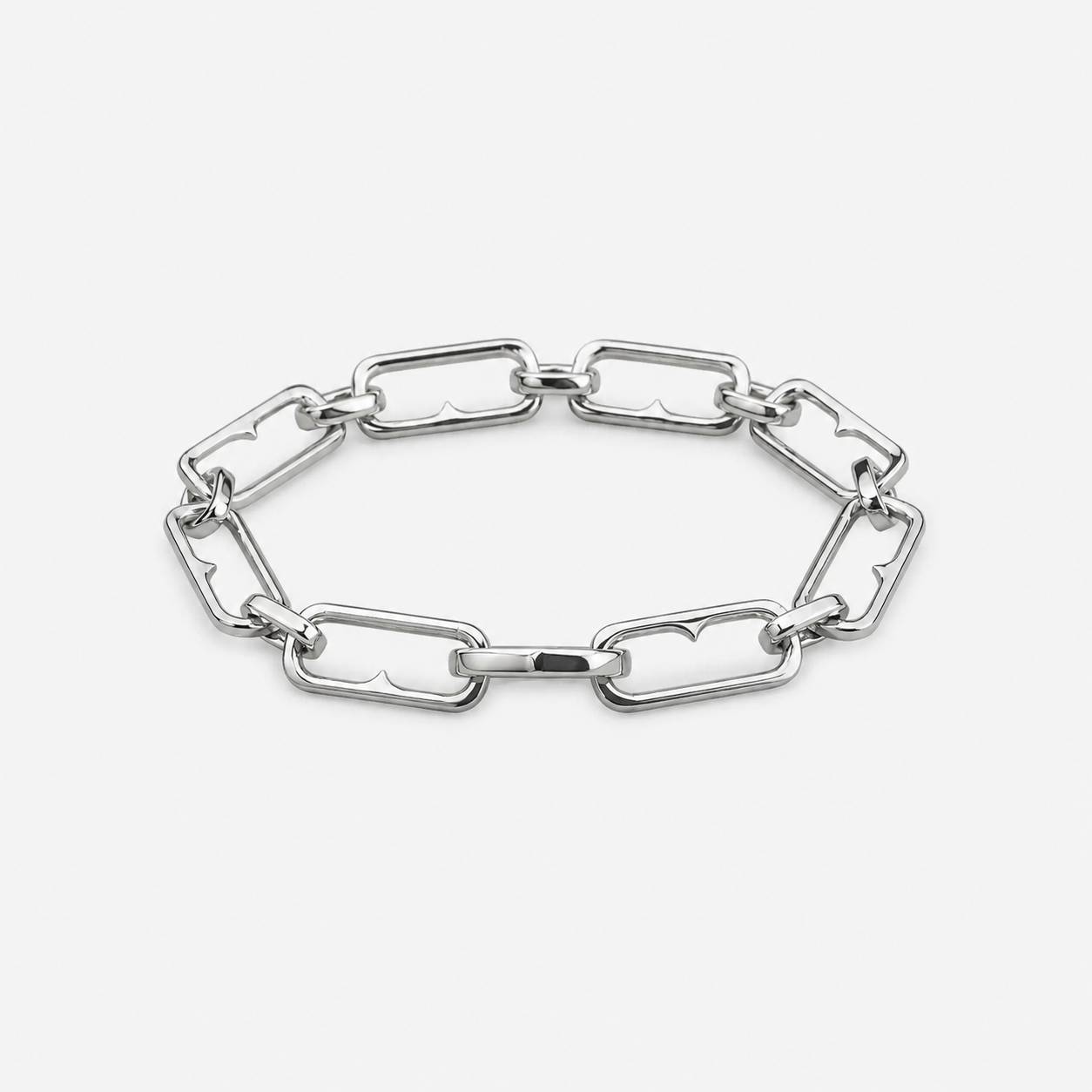 A polished silver-tone chain link bracelet with elongated, rounded rectangular links, displayed on a clean, light gray background.