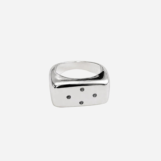 Silver ring with a square design on a light beige background