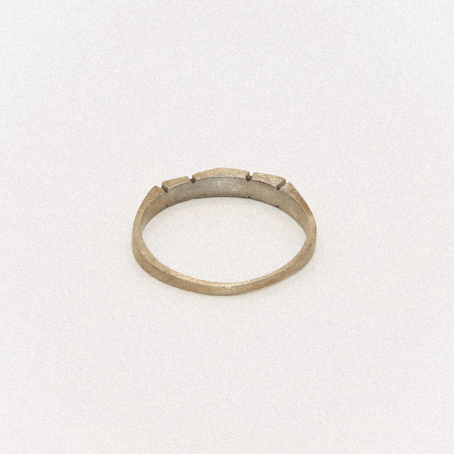 Silver ring with a textured band on a white background