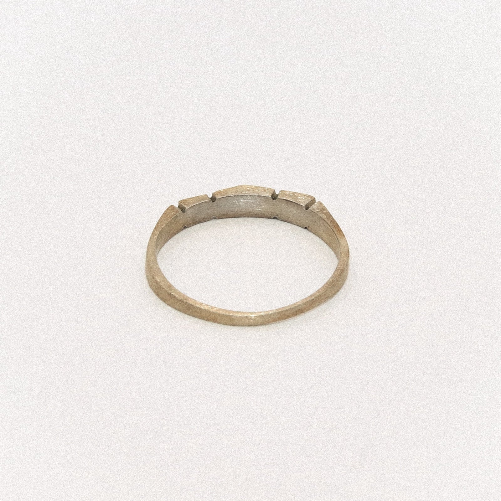 Silver ring with a textured band on a white background