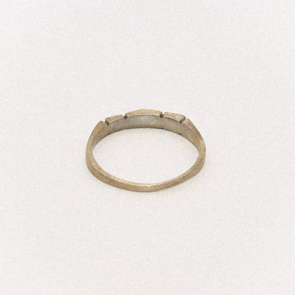 Silver ring with a textured band on a white background