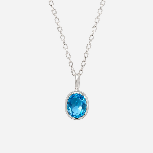 A silver chain necklace with an oval-cut bright blue gemstone pendant in a bezel setting, shown against a plain white background.