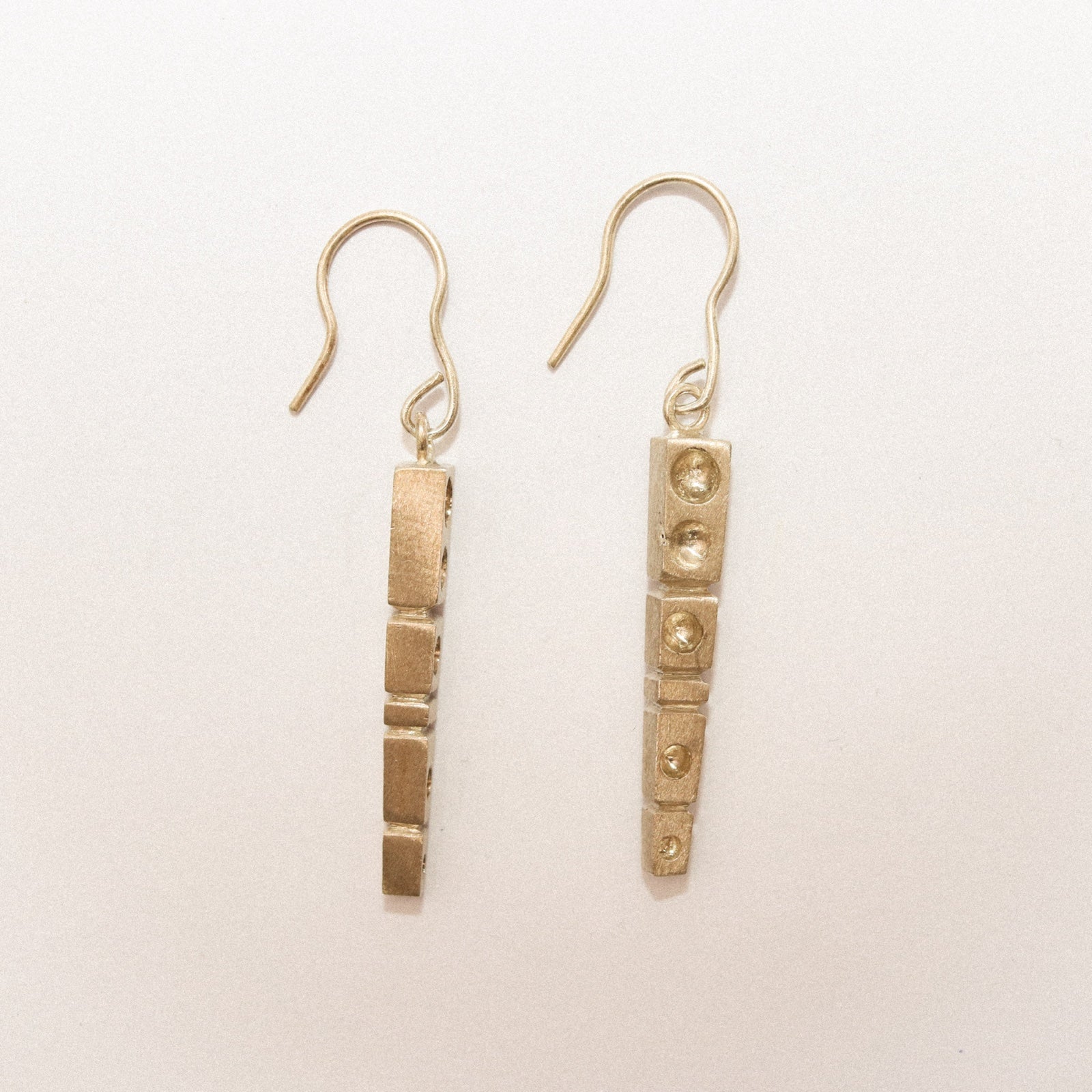 Pair of gold earrings on a light beige background