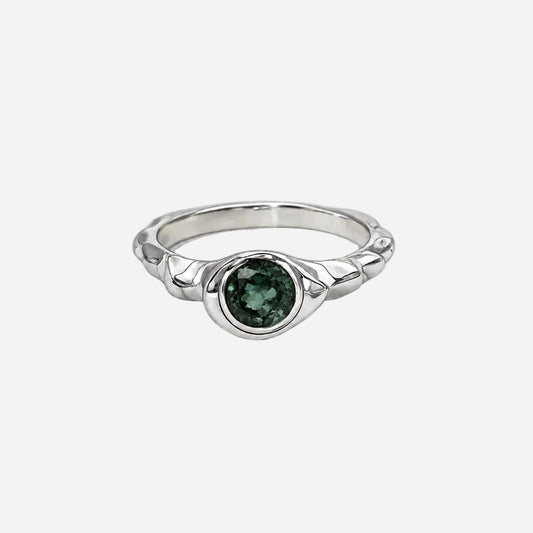Ring with a blue gemstone and rose gold band on a white background