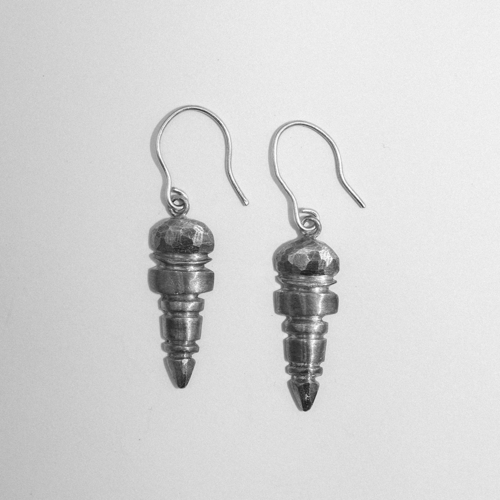 Pair of silver spiral earrings on a light gray background