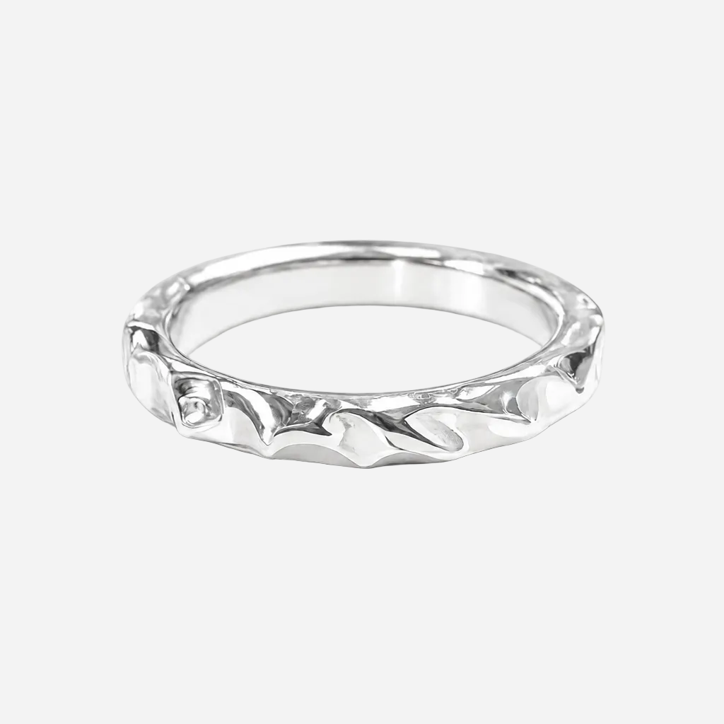 Silver ring with intricate design on a white background
