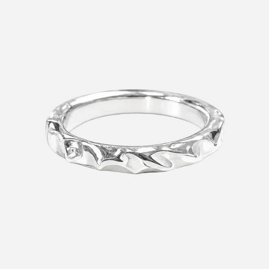 Silver ring with intricate design on a white background