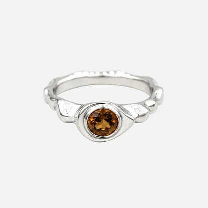 Silver ring with a brown gemstone on a white background