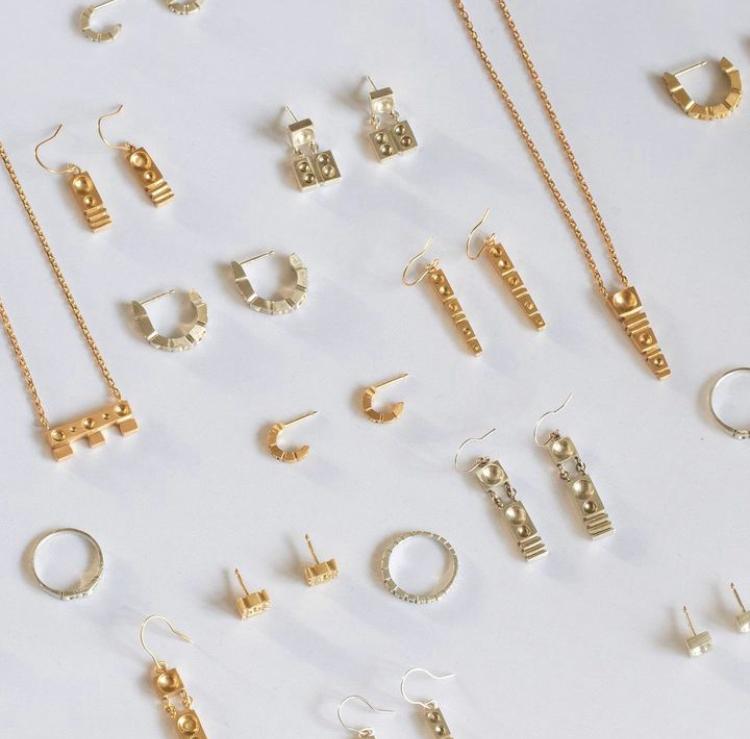 Collection of gold jewelry including earrings and necklaces on a white background