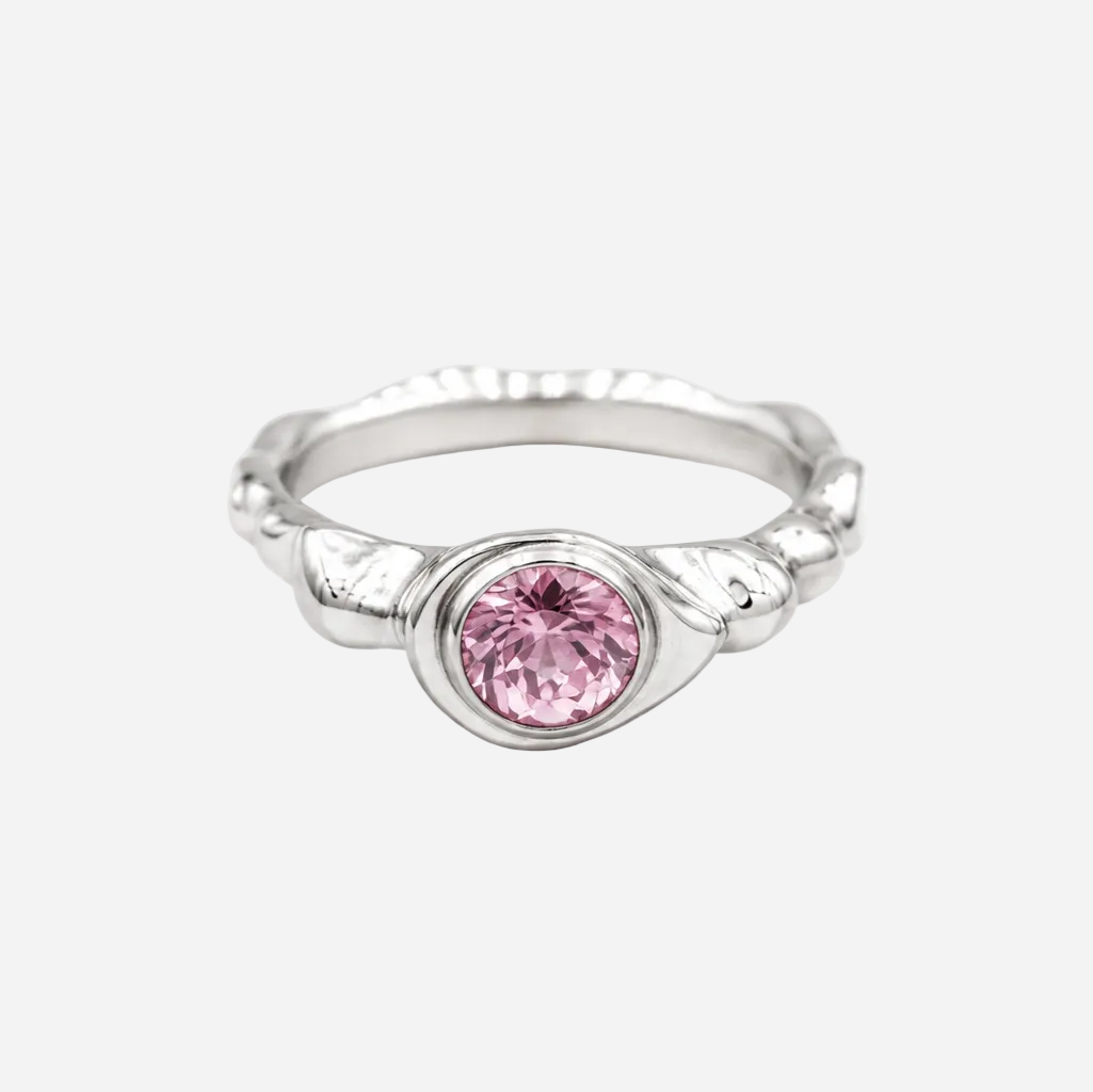 Silver ring with a pink gemstone on a white background