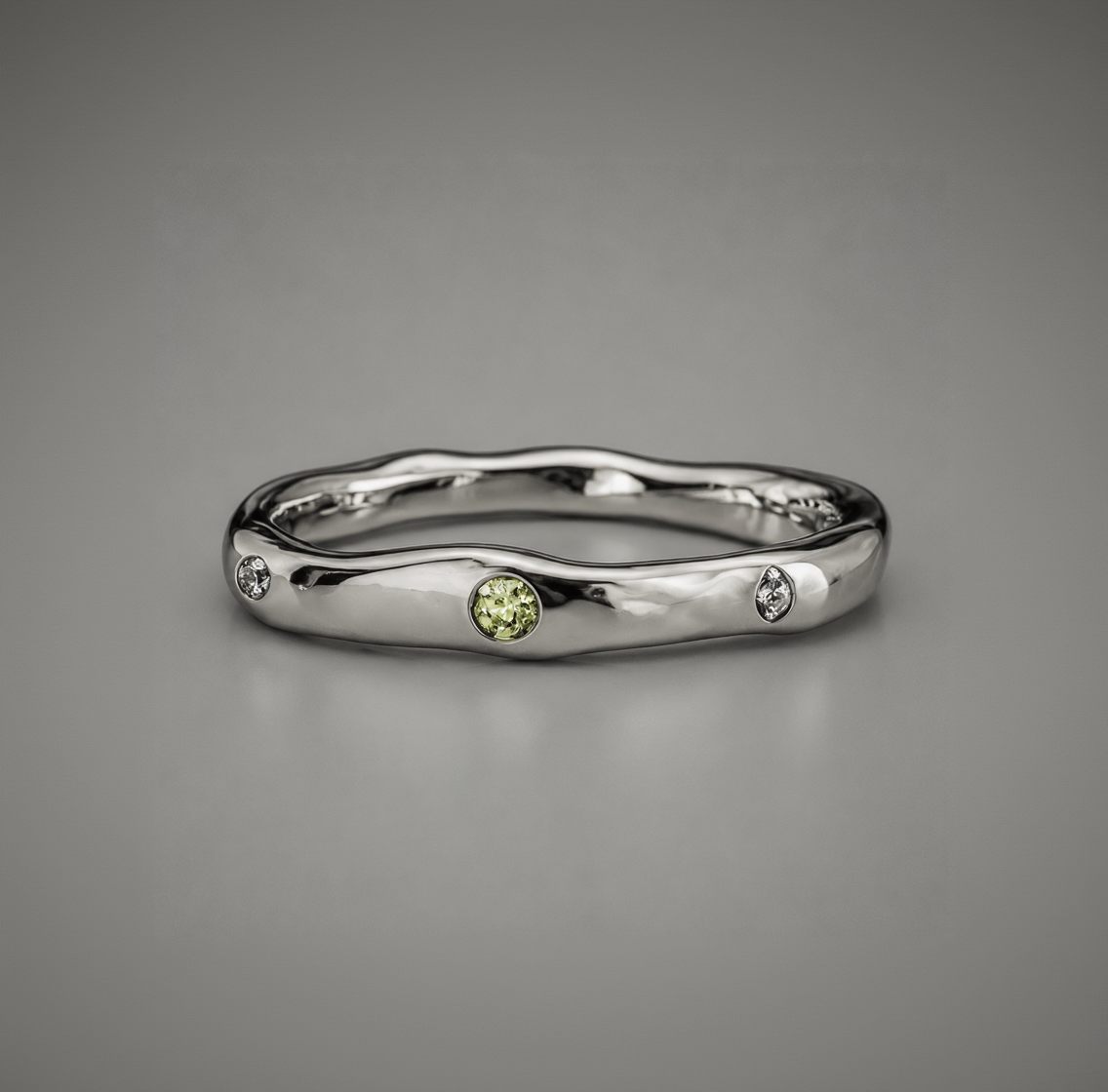 Silver ring with a green gemstone on a gray background