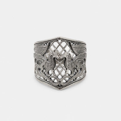 Silver ring with intricate design on a light gray background