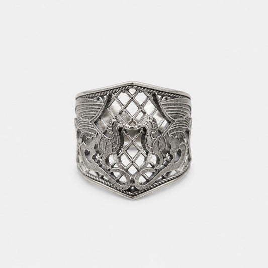 Silver ring with intricate design on a light gray background